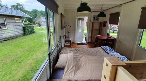 a bedroom with a bed and a large window at Natuurpoort van Loon in Loon op Zand