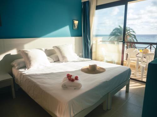 ein Bett mit Hut und zwei Handtüchern darauf in der Unterkunft Prope Mare Apartamentos in Cala Millor