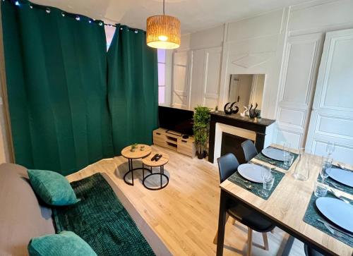 - un salon avec une table et un rideau vert dans l'établissement Studio au coeur de Rouen, 4 personnes, calme & élégant, à Rouen
