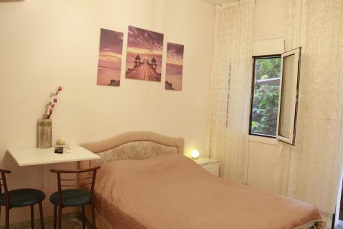 um quarto com uma cama, uma mesa e uma janela em Apartment Eirina em Atenas