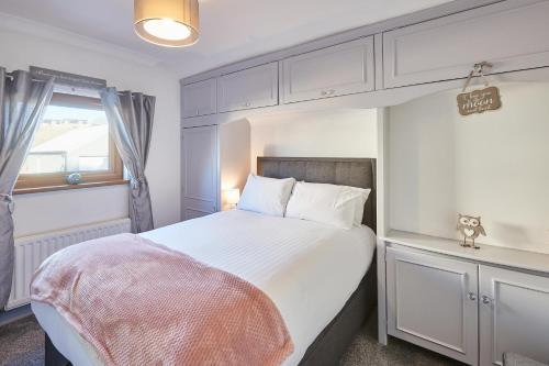 a bedroom with a large white bed and a window at Host & Stay - The Chimneys in Alnmouth