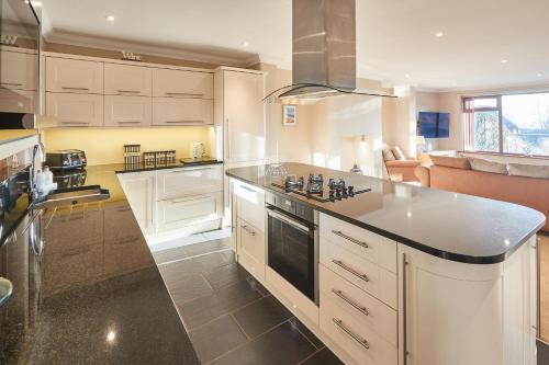 a kitchen with white cabinets and a stove top oven at Host & Stay - The Chimneys in Alnmouth