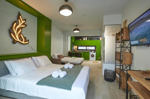 a bedroom with a white bed with a green wall at Olea Apartments in Thessaloniki