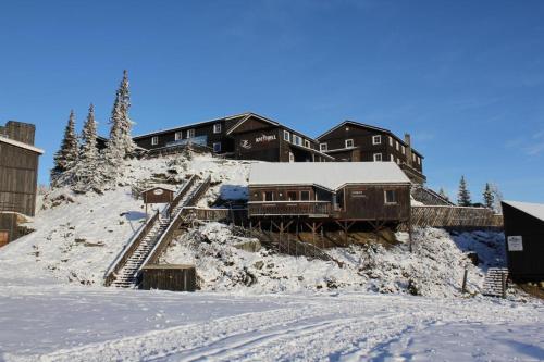 una casa en una colina cubierta de nieve con un tren en Kvitfjell Hotel Kvitfjellvegen 492, en Kvitfjell