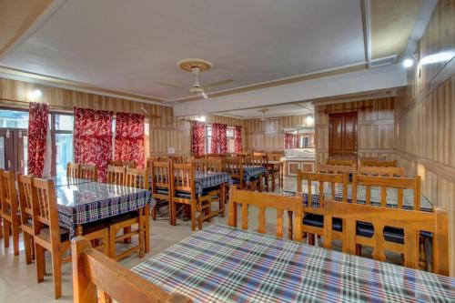 comedor con mesas de madera y sillas de madera en Hotel Luxury Inn, en Srinagar