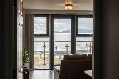 a living room with a couch and a view of the ocean at Galway Bay Sea View Apartments in Galway