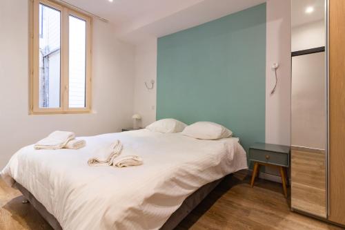 une chambre avec un lit avec des draps blancs et une fenêtre dans l'établissement Taur STREET 4, à Toulouse