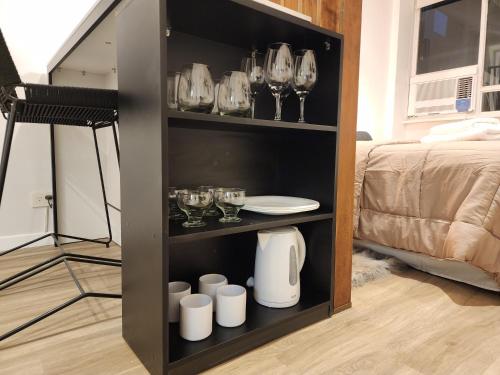 una estantería de libros negros con copas y copas de vino en G&G Apartments - Recoleta Cozy Studio en Buenos Aires