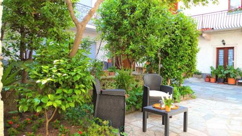 eine Terrasse mit Stühlen, einem Tisch und Bäumen in der Unterkunft Miryam in Baveno