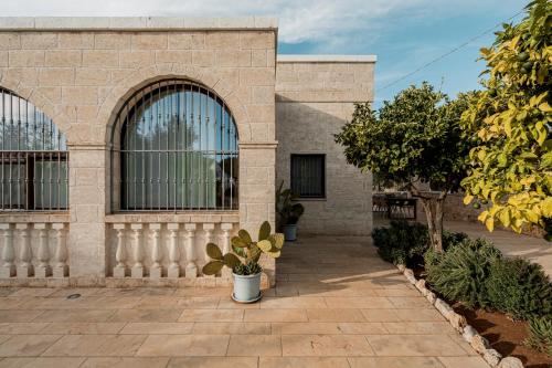 a brick building with two large windows and plants at VILLA OSTUNI ONE mit Pool, Gästehaus & Glamping in Ostuni