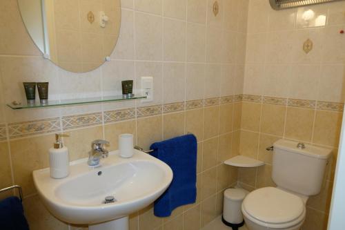 a bathroom with a sink and a toilet and a mirror at Au Chiron in Néré