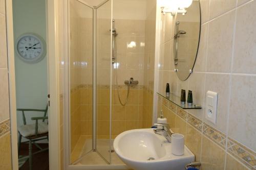 een badkamer met een wastafel en een douche bij Au Chiron in Néré