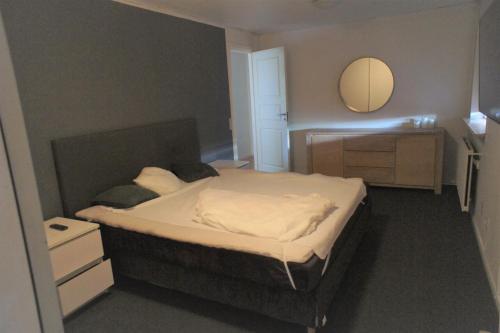 a bedroom with a bed with a mirror on the wall at 102 Fyrrelunden (id. 083) in Esbjerg