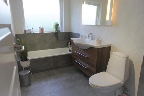 a bathroom with a toilet and a sink and a tub at 102 Fyrrelunden (id. 083) in Esbjerg