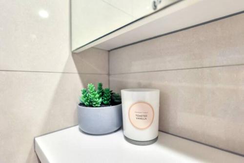 a candle and a potted plant sitting on a counter at Luxury two-beds harbour views apartment in Darwin