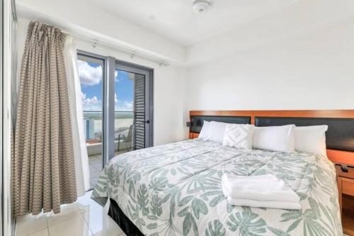 a bedroom with a bed and a large window at Luxury two-beds harbour views apartment in Darwin