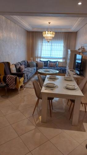 uma sala de estar com uma mesa e um sofá em ESPACIOSO em Tânger