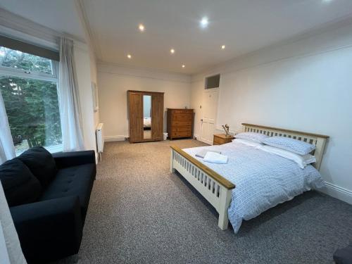 a bedroom with a bed and a couch and a window at Town House A in West House Mews in Dunston