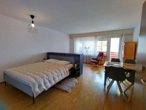 um quarto com uma cama grande, uma secretária e cadeiras em Erli 13 em Leukerbad