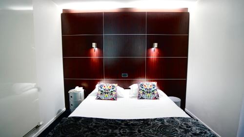 Habitación de hotel con 1 cama con 2 almohadas en Boutique Logis Hôtel Relais de Vincey en Vincey