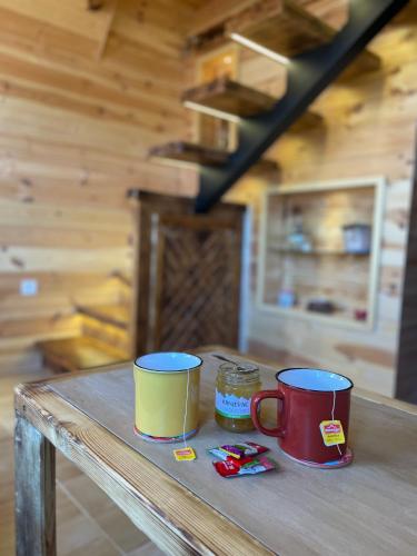 two coffee mugs sitting on a table in a cabin at Family home MASA in Žabljak