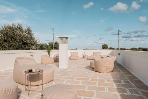 a patio with chairs and a table on a roof at VILLA OSTUNI ONE mit Pool, Gästehaus & Glamping in Ostuni