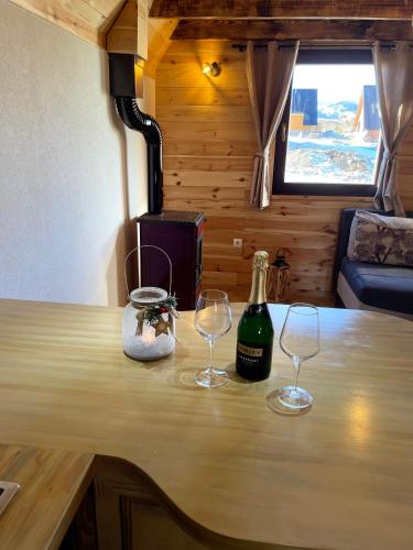two glasses and a bottle of wine on a table at Family home MASA in Žabljak