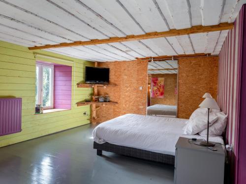 a bedroom with yellow and pink walls and a bed at La Maison de Max - avec terrasse in Saulxures-sur-Moselotte