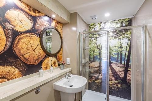 a bathroom with a wall mural of trees at Squirrel Lodge 40 with Hot Tub in Newton Stewart