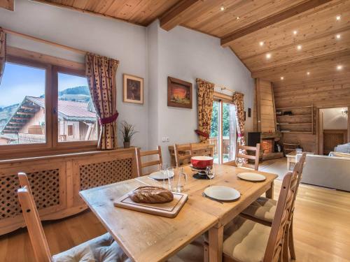 une salle à manger avec une table en bois et une grande fenêtre dans l'établissement Charmant Appt 3 Chambres à Megève, Proche Pistes, Balcon ensoleillé, Cheminée et Garage - FR-1-453-6, à Megève