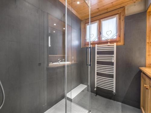 une douche en verre dans une salle de bain avec un lavabo dans l'établissement Charmant Appt 3 Chambres à Megève, Proche Pistes, Balcon ensoleillé, Cheminée et Garage - FR-1-453-6, à Megève
