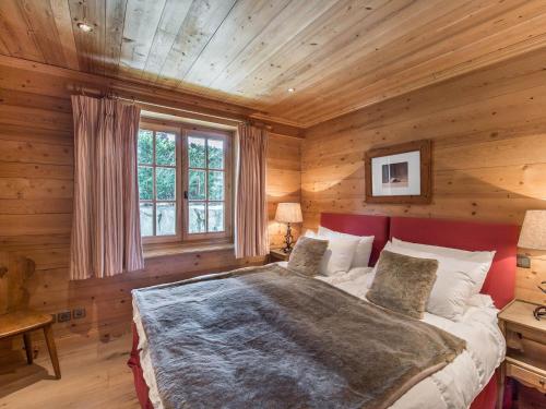 ムジェーヴにあるChalet Megève, 5 pièces, 8 personnes - FR-1-453-12の木製の壁のベッドルーム1室(大型ベッド1台付)