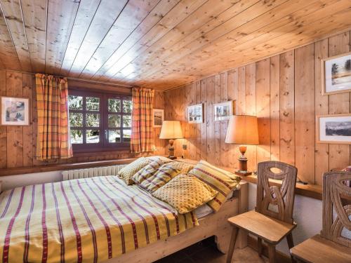 a bedroom with a bed and a wooden wall at Chalet Megève, 5 pièces, 10 personnes - FR-1-453-10 in Megève