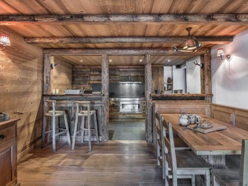 - une cuisine avec des murs en bois, des tables et des tabourets en bois dans l'établissement Location Apt 4P rénové avec terrasse et jardin - Proche centre et ROCHEBRUNE - Garage inclus - FR-1-453-35, à Megève