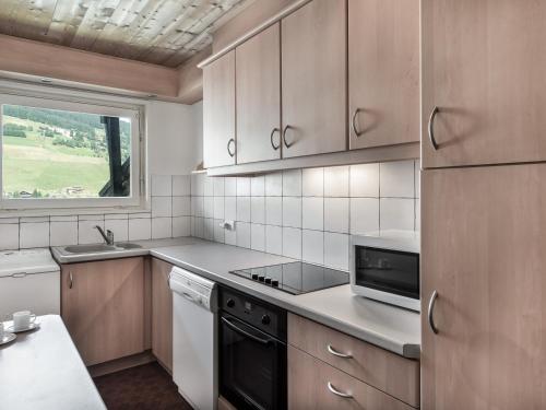 une cuisine avec des appareils électroménagers blancs et une fenêtre dans l'établissement Appartement cosy 2 chambres au centre de Megève avec balcon, animaux admis - FR-1-453-37, à Megève