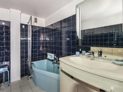 une salle de bain avec un lavabo, une baignoire et un miroir dans l'établissement Charmant studio duplex au centre de Megève, 4 pers, balcon, parking, proximité commerces - FR-1-453-44, à Megève