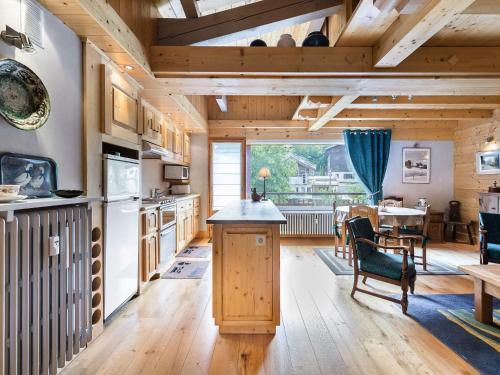 Il comprend une cuisine avec des plafonds en bois, une table et des chaises. dans l'établissement Charmant studio duplex au centre de Megève, 4 pers, balcon, parking, proximité commerces - FR-1-453-44, à Megève