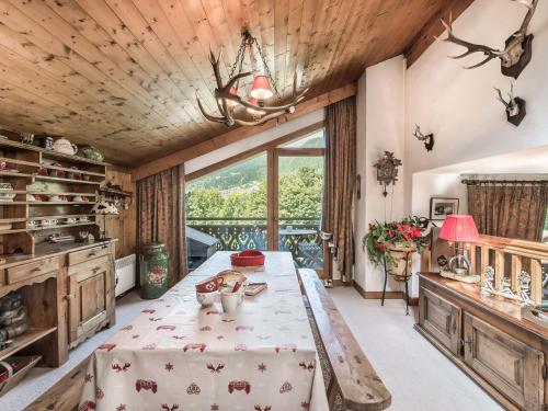 une salle à manger avec une table et une grande fenêtre dans l'établissement Charmant Duplex 3 Chambres avec Cheminée, Balcons et Piscine - Proche Centre Megève - FR-1-453-42, à Megève