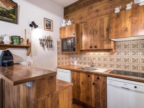 une cuisine avec des armoires en bois et un évier dans l'établissement Appartement 2 Chambres à Megève Rochebrune - Terrasse et Jardin, Proche Téléphérique - FR-1-453-52, à Megève