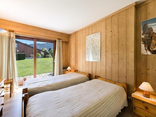 deux lits dans une chambre avec une fenêtre dans l'établissement Charmant T2 Rez-de-Jardin, Terrasse, Proche Pistes et Centre, Animaux Bienvenus, Garage Inclus - FR-1-453-61, à Megève