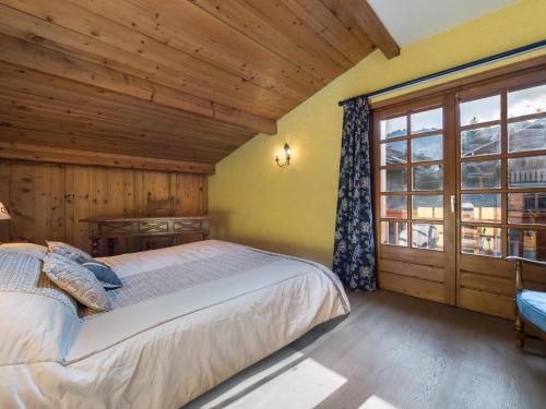 une chambre avec un lit et une grande fenêtre dans l'établissement Charmant appartement 3 pièces à Megève, proche centre, balcon, WiFi, 4 pers, skis, sans parking - FR-1-453-78, à Megève
