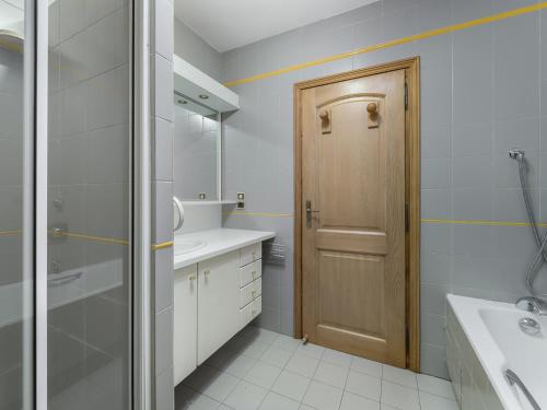 La salle de bains est pourvue d'un lavabo et d'une porte en bois. dans l'établissement Charmant appartement 3 pièces à Megève, proche centre, balcon, WiFi, 4 pers, skis, sans parking - FR-1-453-78, à Megève