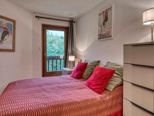 ムジェーヴにあるAppartement Megève, 3 pièces, 4 personnes - FR-1-453-101のベッドルーム1室(赤い枕のベッド1台、窓付)