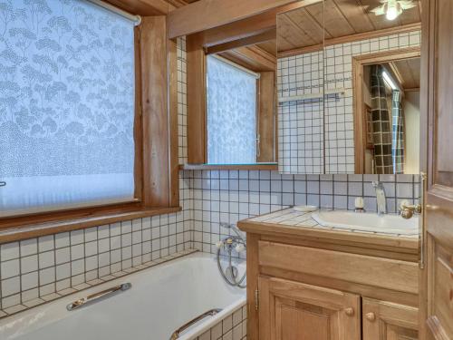 a bathroom with a tub and a sink and a mirror at Appartement Megève, 2 pièces, 4 personnes - FR-1-453-105 in Megève