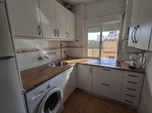 uma cozinha com um lavatório e uma máquina de lavar roupa em Apartamento céntrico con vistas em Melilha