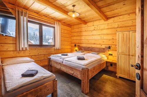 a bedroom with two beds in a log cabin at Chata Líška JASNA in Liptovský Mikuláš