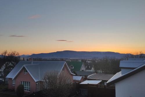 a group of buildings with the sunset in the background at Icelandic Art Garden Villa w. parking in centre city in Reykjavík