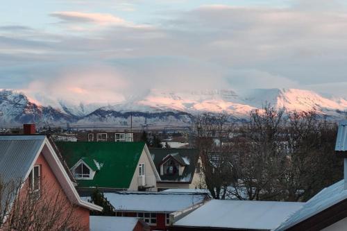 a city with snow covered mountains in the background at Icelandic Art Garden Villa w. parking in centre city in Reykjavík