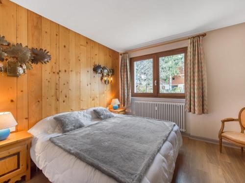 une chambre avec un grand lit et des murs en bois dans l'établissement Appartement 62m² 4 pers. à Megève - Centre, Balcon Sud/Est, Parking, 2 étoiles - FR-1-453-118, à Megève