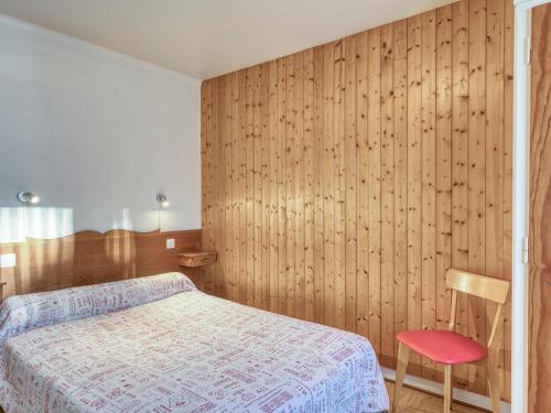 a bedroom with a bed and a wooden wall at Appartement Megève, 2 pièces, 3 personnes - FR-1-453-120 in Megève
